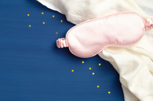 Schlafmaske, Bettdecke und Sterne am blauen Hintergrund